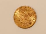 a close up of a gold coin on a white surface