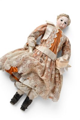 une poupée ancienne représentant une femme en robe et bottes