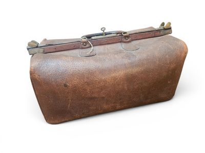 a brown leather bag with a metal handle on a white surface