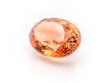 a close up of an orange diamond on a white surface