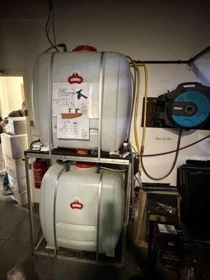 une photo d'un réservoir muni d'un tuyau, dans un garage