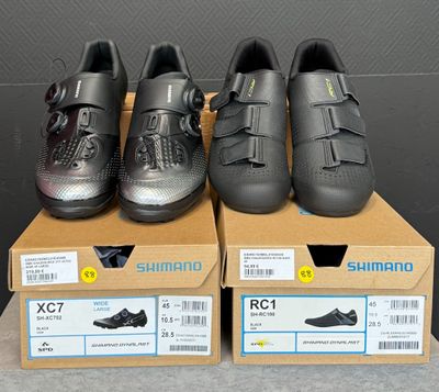 Plusieurs paires de chaussures sont posées sur des cartons, sur une table.