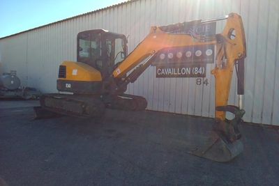 a picture of a small excavator parked in front of a building