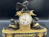 une horloge surmontée d'une statue d'aigle