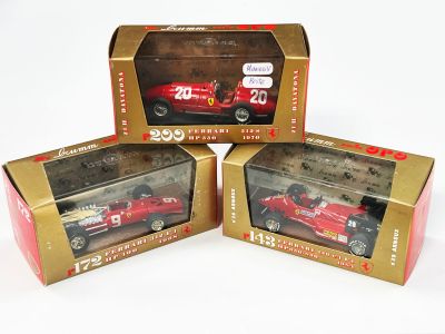 trois boîtes contenant chacune une maquette de voiture de course rouge