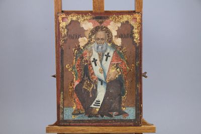 an old painting of a man sitting on a easel with a cross on it