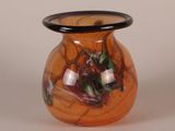 a glass vase with a black rim on a white surface