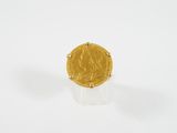 gros plan d'une pièce d'or sur une surface blanche