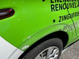 a green and white car parked on the side of the road