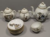 a white tea pot with a cup and saucer on it