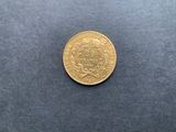 a close up of a gold coin on a blue surface