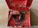 an open tool box sitting on the floor next to a person ' s feet