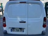 the back end of a white van parked in a parking lot