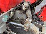 a close up of a red motorcycle with a chain attached to it ' s rear end