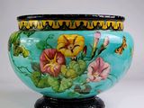 un vase orné de fleurs peintes, posé sur un socle