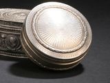 a silver box sitting on a table with a black background