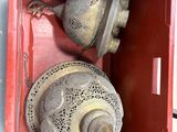 une boîte rouge contenant deux clochettes, sur laquelle est posé un papillon