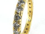 a close up of a yellow gold ring with black diamonds