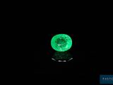 a close up of a green emerald on a black surface