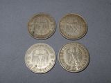 four different coins sitting on top of a table next to each other
