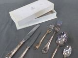 cinq fourchettes, un couteau, une cuillère et une boîte posés sur une table