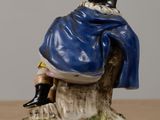 a figurine of a woman sitting on a rock