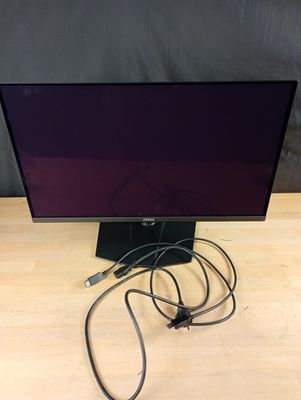 un écran d'ordinateur posé sur un bureau en bois, à côté d'un chargeur