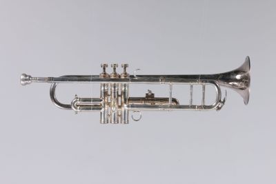 an old silver trumpet is shown against a white background