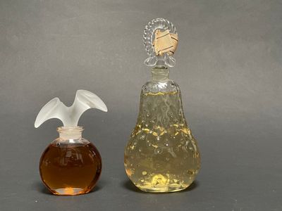 two bottles of perfume sitting next to each other on a table