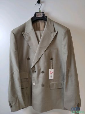 une veste suspendue à un cintre accroché au mur, avec une étiquette dessus
