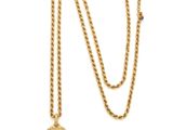 a close up of a gold necklace with a chain on a white background
