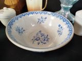 a blue and white bowl sitting on a table next to a vase