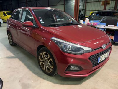 the red car is parked in a garage with other cars in the background