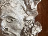 a sculpture of a man with a bunch of grapes on his head