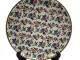 a close up of a plate with flowers on it on a stand