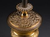 an antique brass table lamp with a flower design on the base