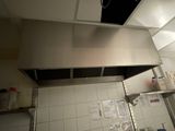 a picture of a commercial kitchen with a stainless steel range hood