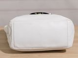 the small white bag is sitting on a wooden table