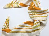 une écharpe orange et blanche ornée d'une chaîne dorée
