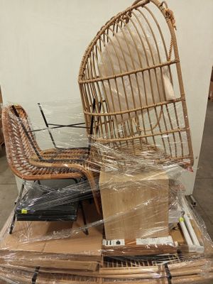 une chaise en osier posée sur une pile de cartons