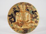 gold plate with a gold buddha sitting on a black and white background