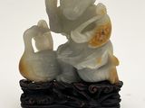 une figurine représentant un homme et un canard assis sur une branche d'arbre