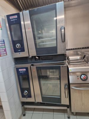plusieurs fours et cuisinières en acier inoxydable dans une cuisine professionnelle