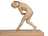 statue of a man bending over on a base with his hands on his head