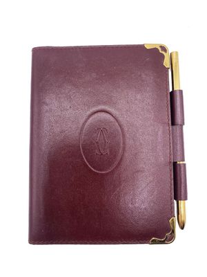a close up of a leather notebook with a pen on it