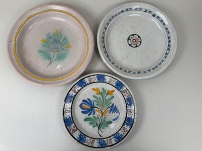 trois assiettes à motifs différents posées sur une surface blanche