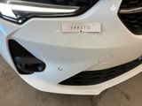 a close up of the front bumper of a white car