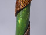 a close up of a green stick with a snake wrapped around it