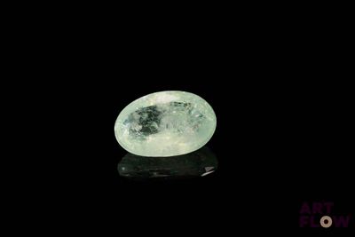 une image représentant un quartz vert posé sur une surface noire