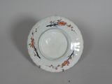 a white plate with orange flowers on it on a table